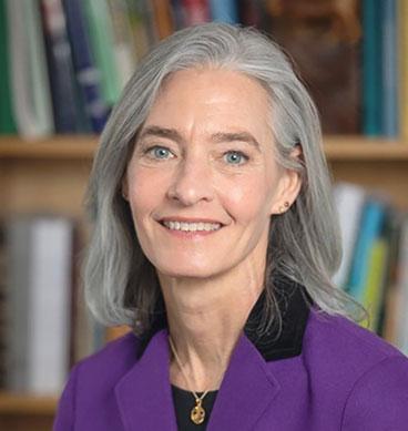 headshot of woman with silver hair, purple blouse