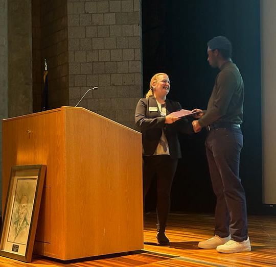 man getting a certificate from woman standing at podium